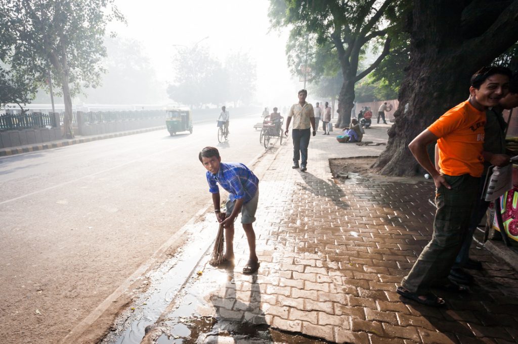 Boy cleaning the street in India