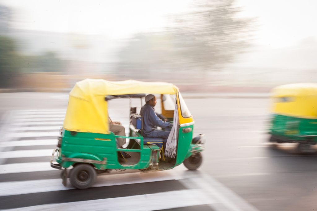Tuk tuk speeding down the street in Delhi, India