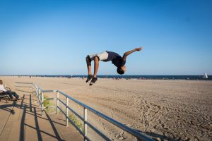 Coney Island street photography of a kid doing a back flip