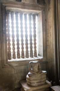 Sun on a headless statue for an article on Angkor Wat travel tips