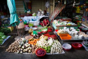 Woman fixing vegetables for an article on the Cai Be Floating Markets