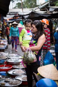 Mother and child at market for an article on the Cai Be Floating Markets
