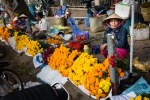 Woman selling marigolds for an article on the Cai Be Floating Markets