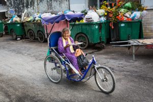 Old woman on bike for an article on the Cai Be Floating Markets