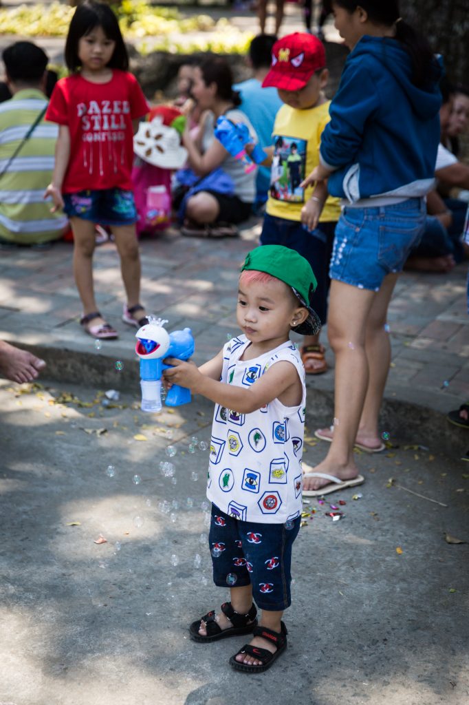 Little boy blowing bubbles at the Saigon Zoo and Botanical Garden for article on Ho Chi Minh City street photos