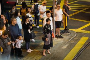 People waiting to cross the street for a Hong Kong street photography series called the view from the ding ding