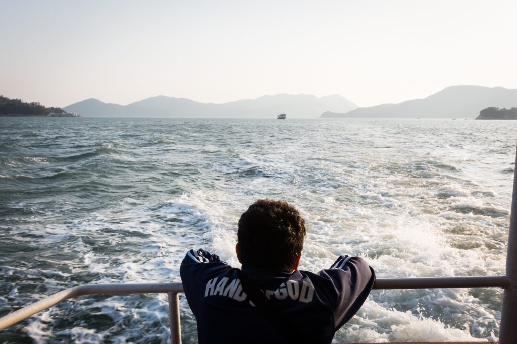 Man traveling on ferry for a Hong Kong travel guide article