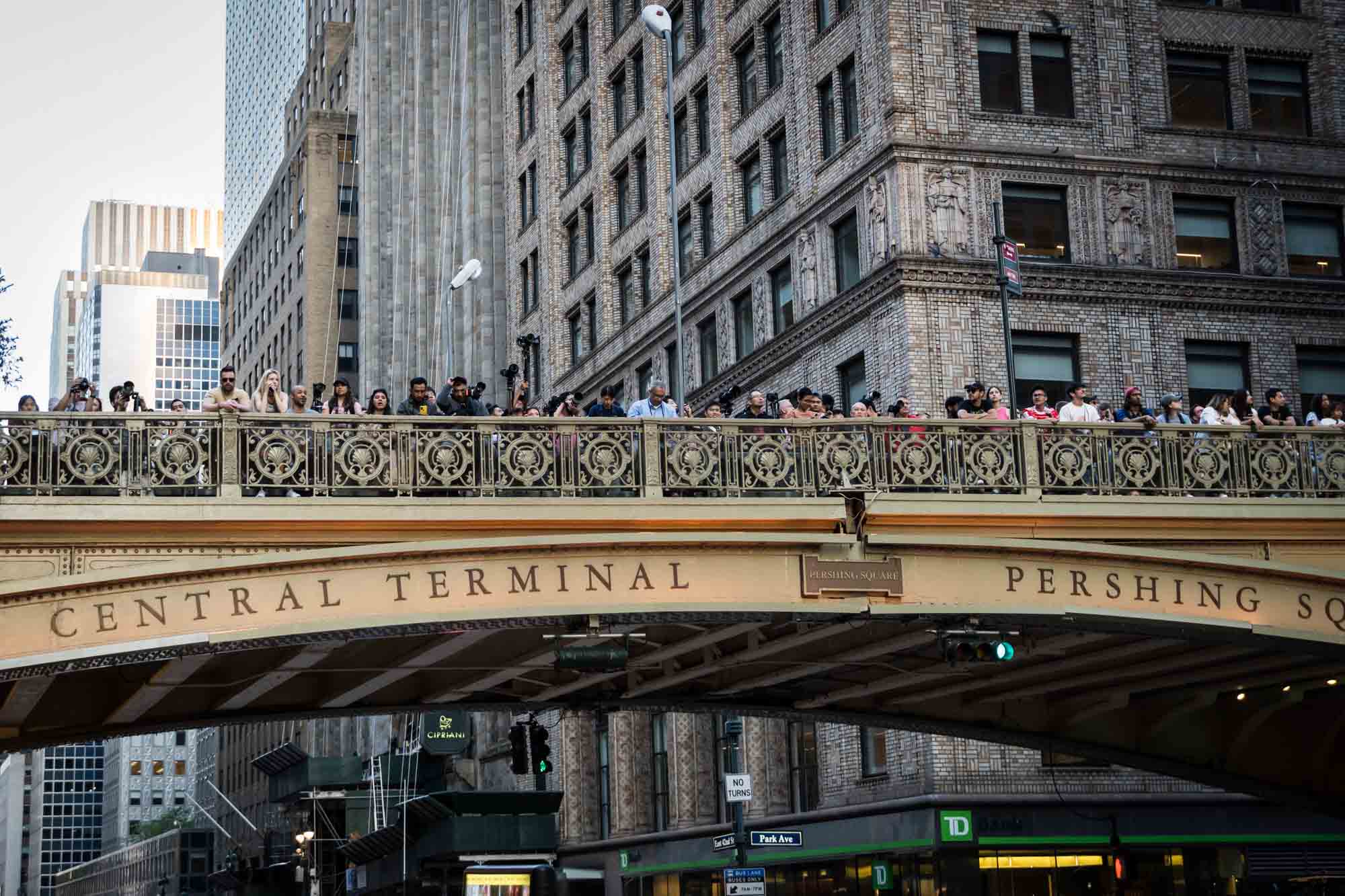 Tourists lined up on Grand Central overpass with cellphones in hand during Manhattanhenge