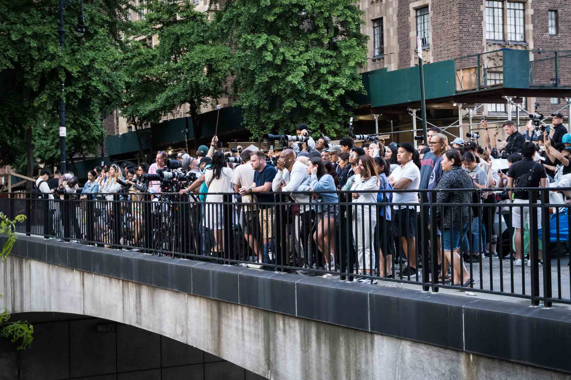 Tourists lined up on Tudor City overpass with cellphones in hand during Manhattanhenge