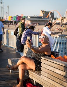 Coney Island street photography of a woman with white turban talking into her phone
