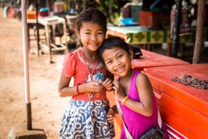 Two little girls smiling for an article on Angkor Wat travel tips