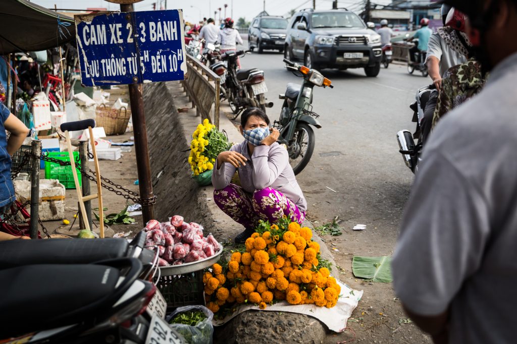 Woman selling marigolds for an article on the Cai Be Floating Markets