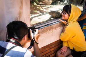 Girl taking selfie with lizard at the Saigon Zoo and Botanical Garden for article on Ho Chi Minh City street photos