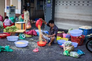 Man pouring rice for article on Ho Chi Minh City street photos