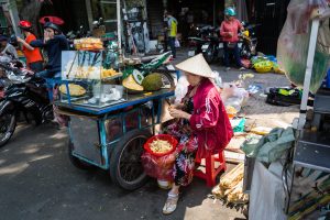 Woman selling fruit in the street for article on Ho Chi Minh City street photos