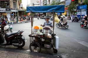 Man selling rice in the street for article on Ho Chi Minh City street photos