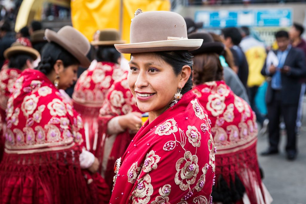 Bolivian girl wearing red shawl and bowler hat