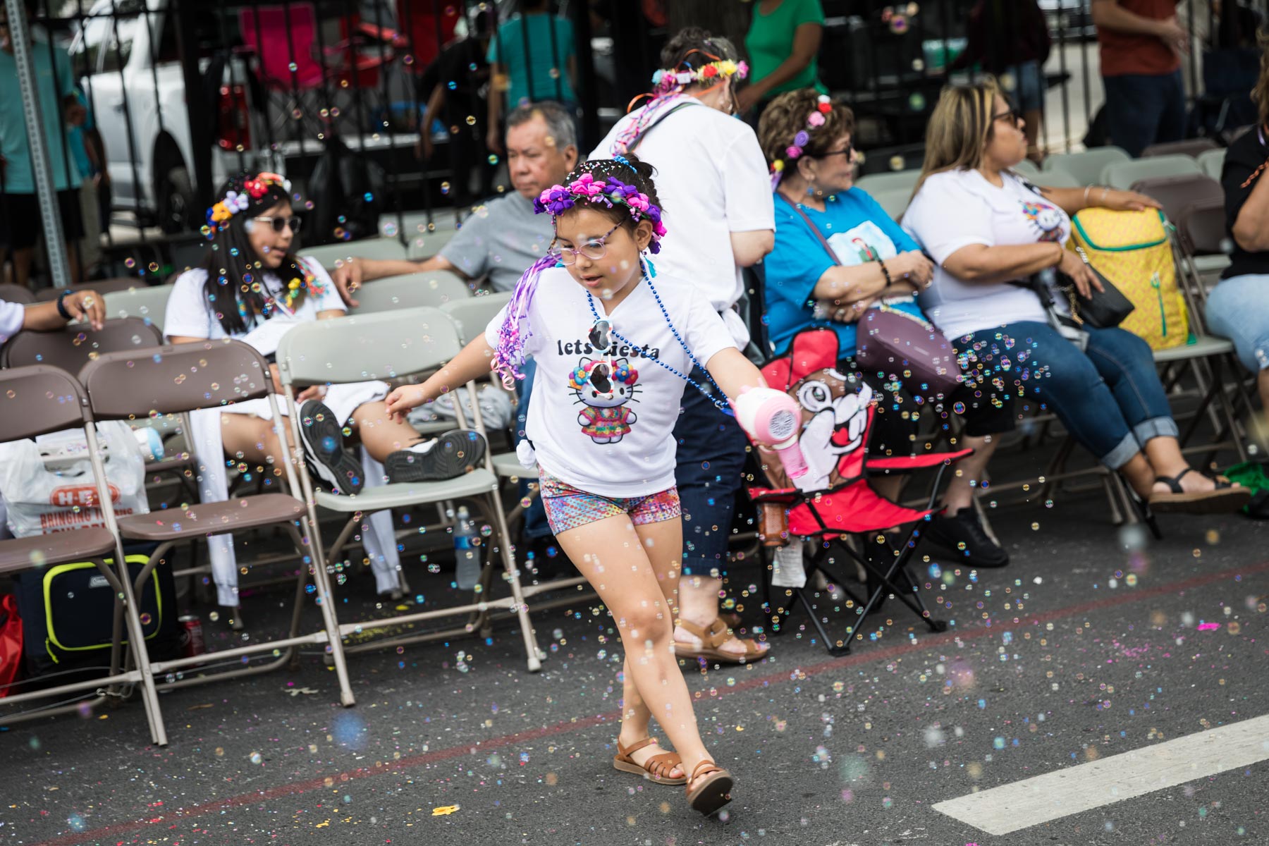 Little girl spinning in front of chair and blowing bubbles for an article on the Fiesta photo tips