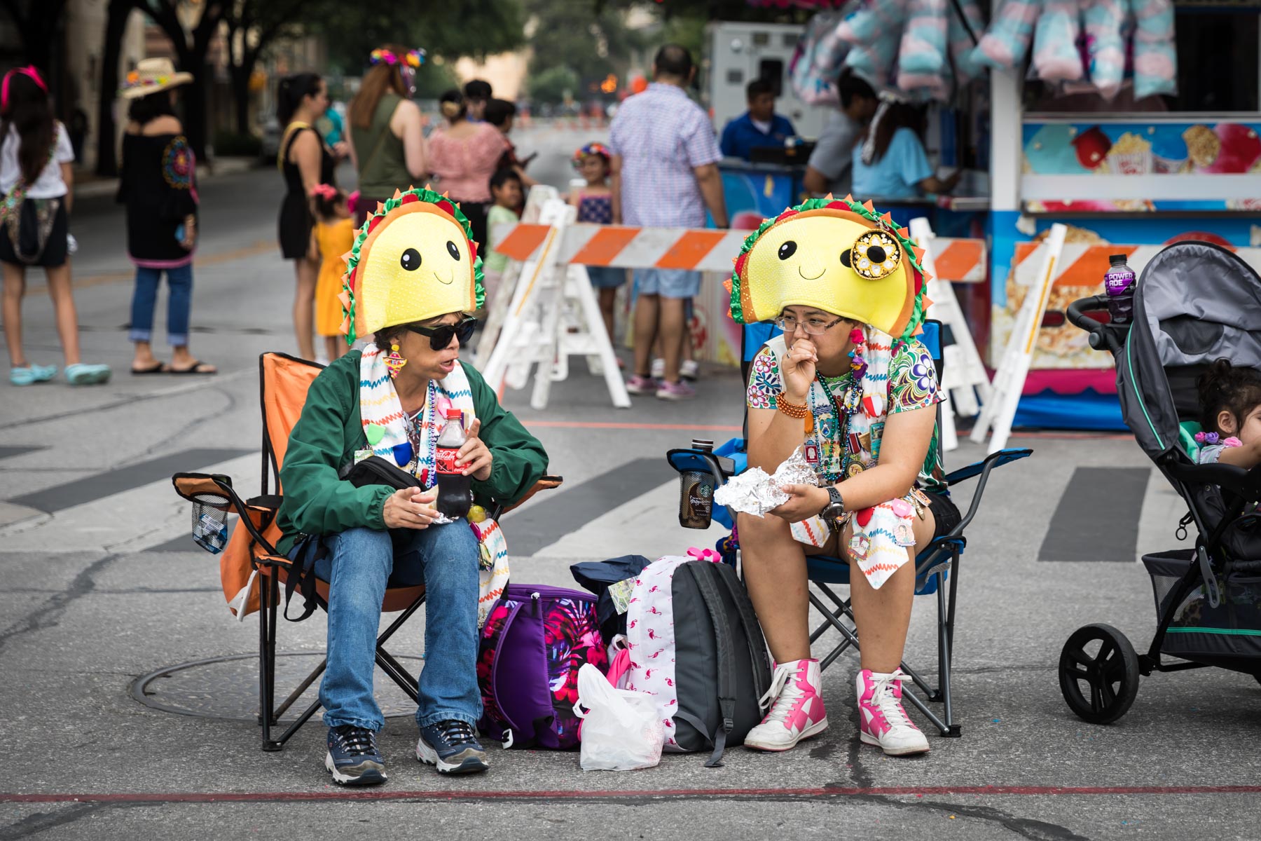 Couple wearing taco-themed hats during Battle of Flowers parade for an article on the Fiesta photo tips