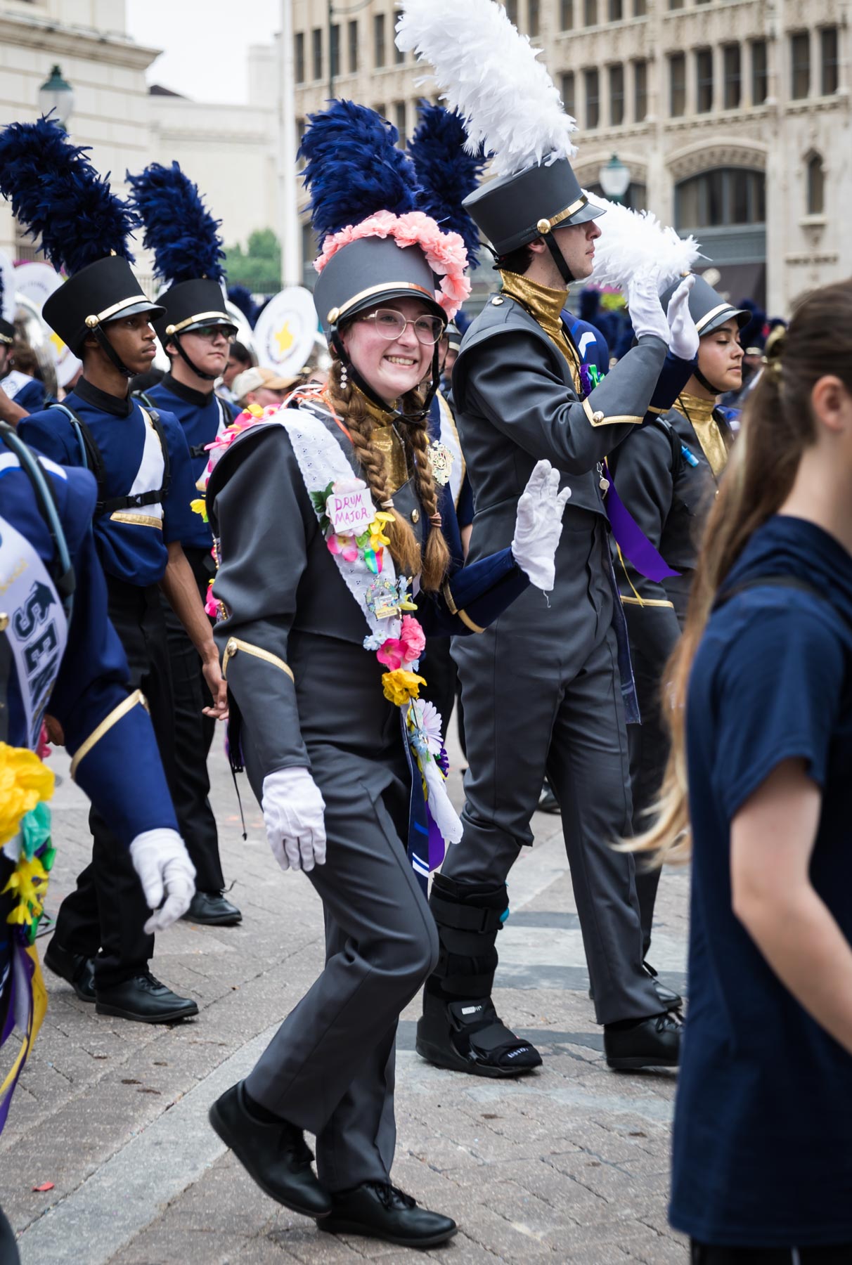 Young female band member waving and wearing colorful sash during Battle of Flowers Parade for an article on the Fiesta photo tips