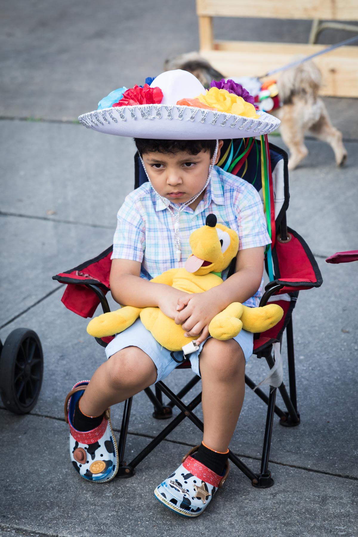 Little boy wearing sombrero and sitting while holding stuffed toy at King William for an article on the Fiesta photo tips