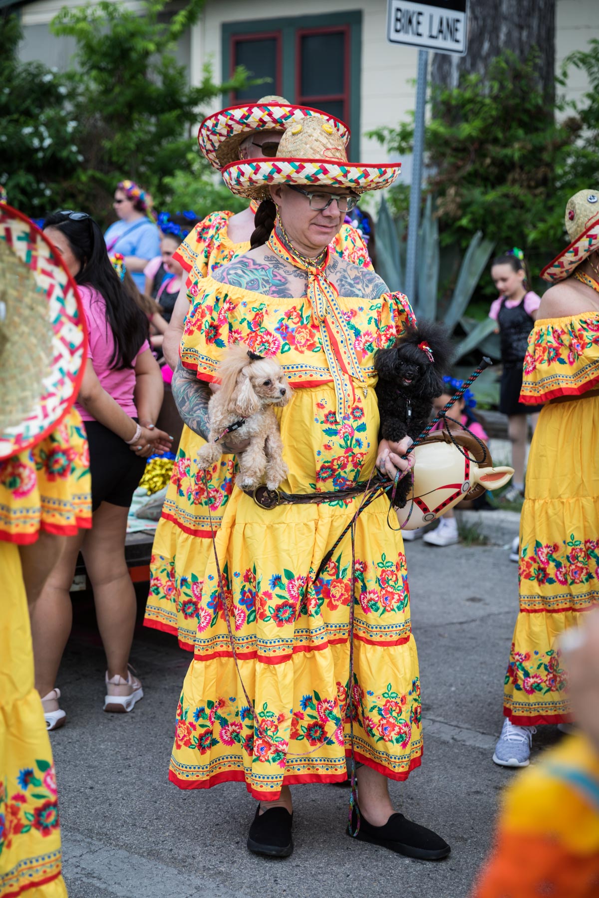 Man wearing yellow dress, sombrero and holding chihuahua for an article on the Fiesta photo tips