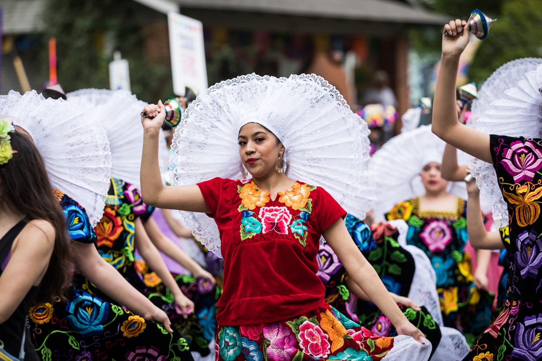 Woman dancing with white hair adornment and colorful dress for an article on the Fiesta photo tips