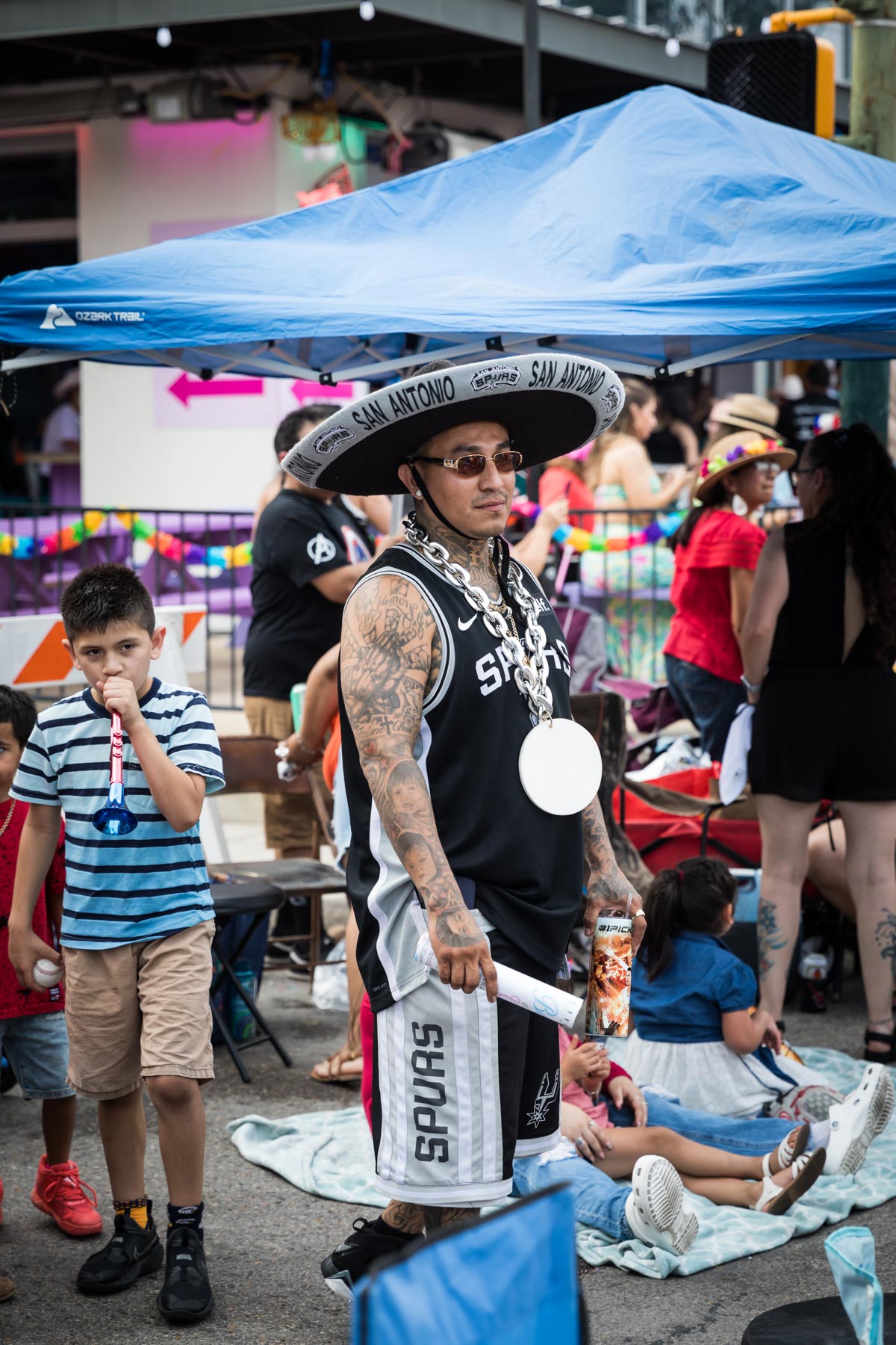 Man with tattoos wearing black Spurs shirt and sombrero for an article on the Fiesta photo tips