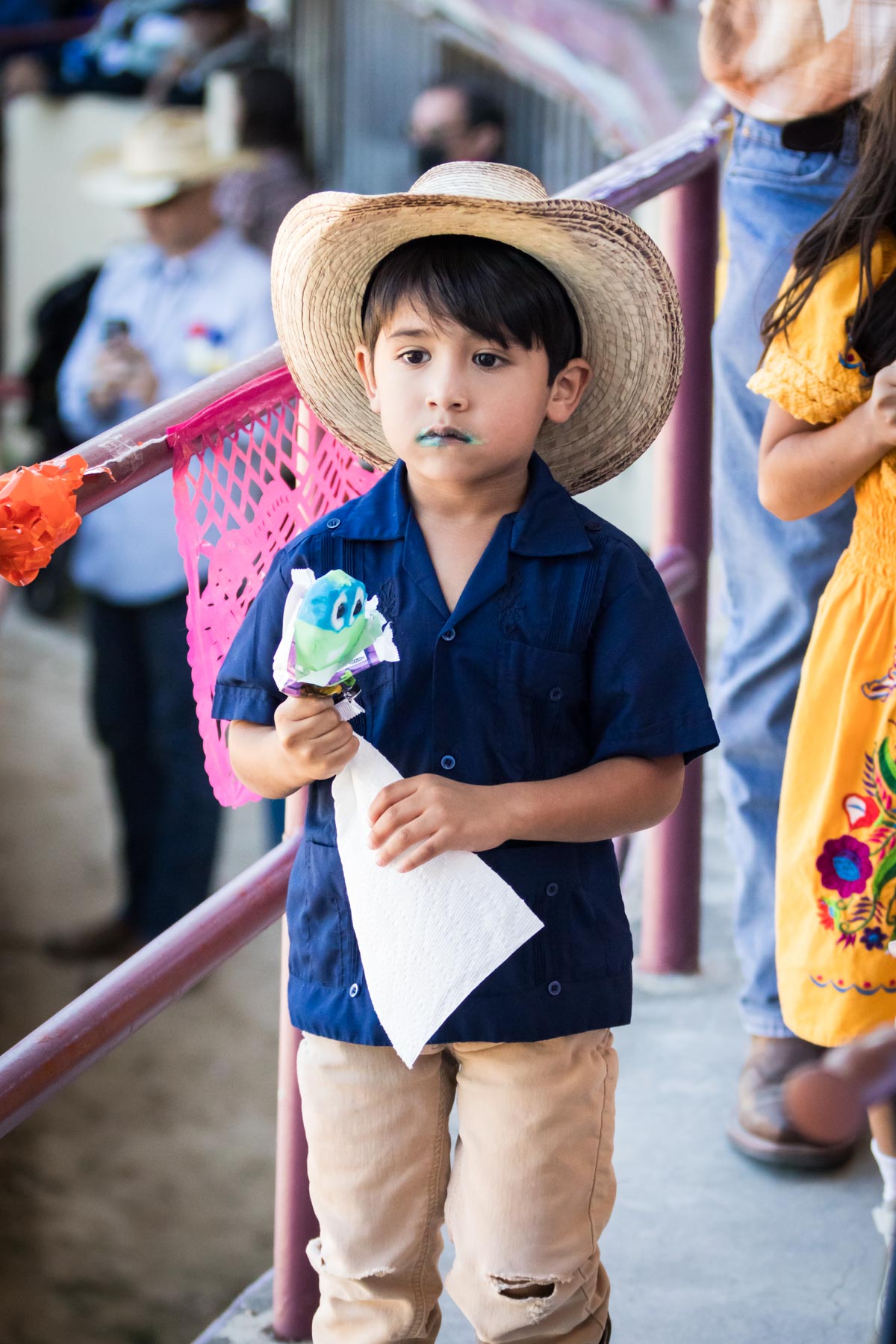 Little boy wearing blue shirt and cowboy hat while holding blue ice cream for an article on the Fiesta photo tips