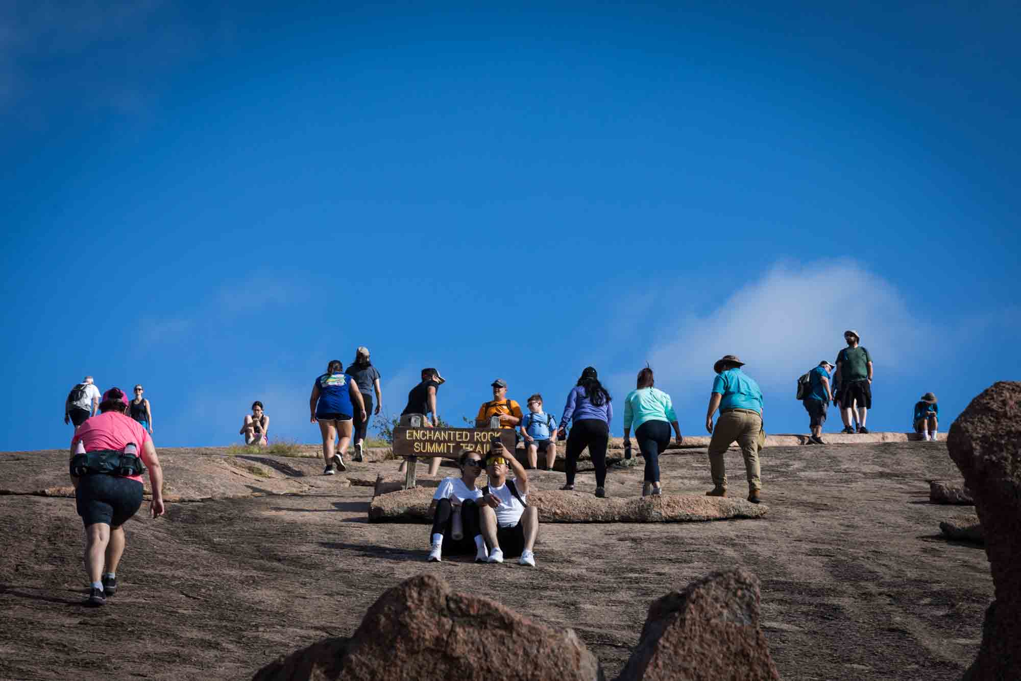 Hikers climbing up the summit for an article on Enchanted Rock hiking trips