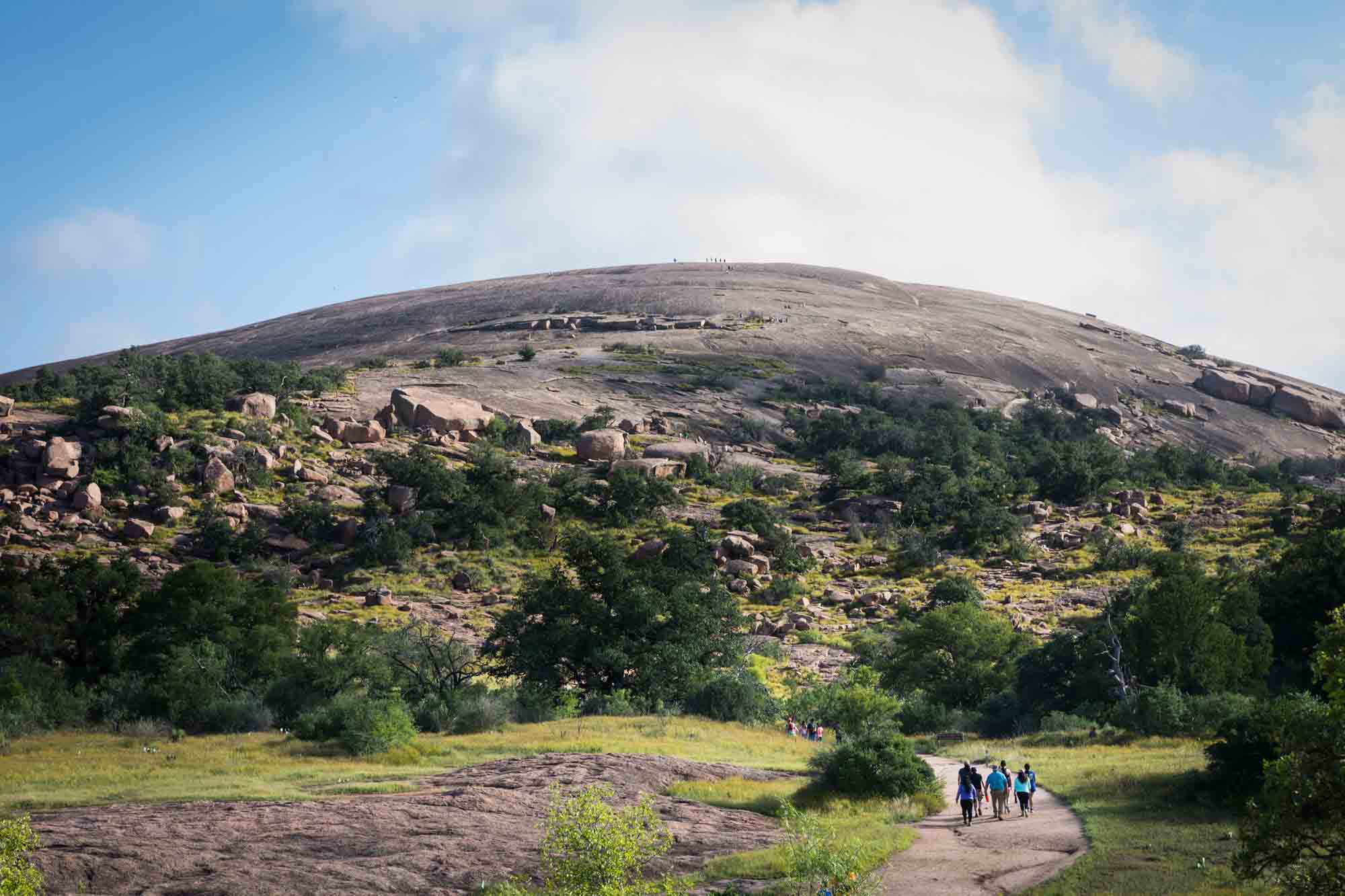 Hikers on pathway leading to mountain for an article on Enchanted Rock hiking trips