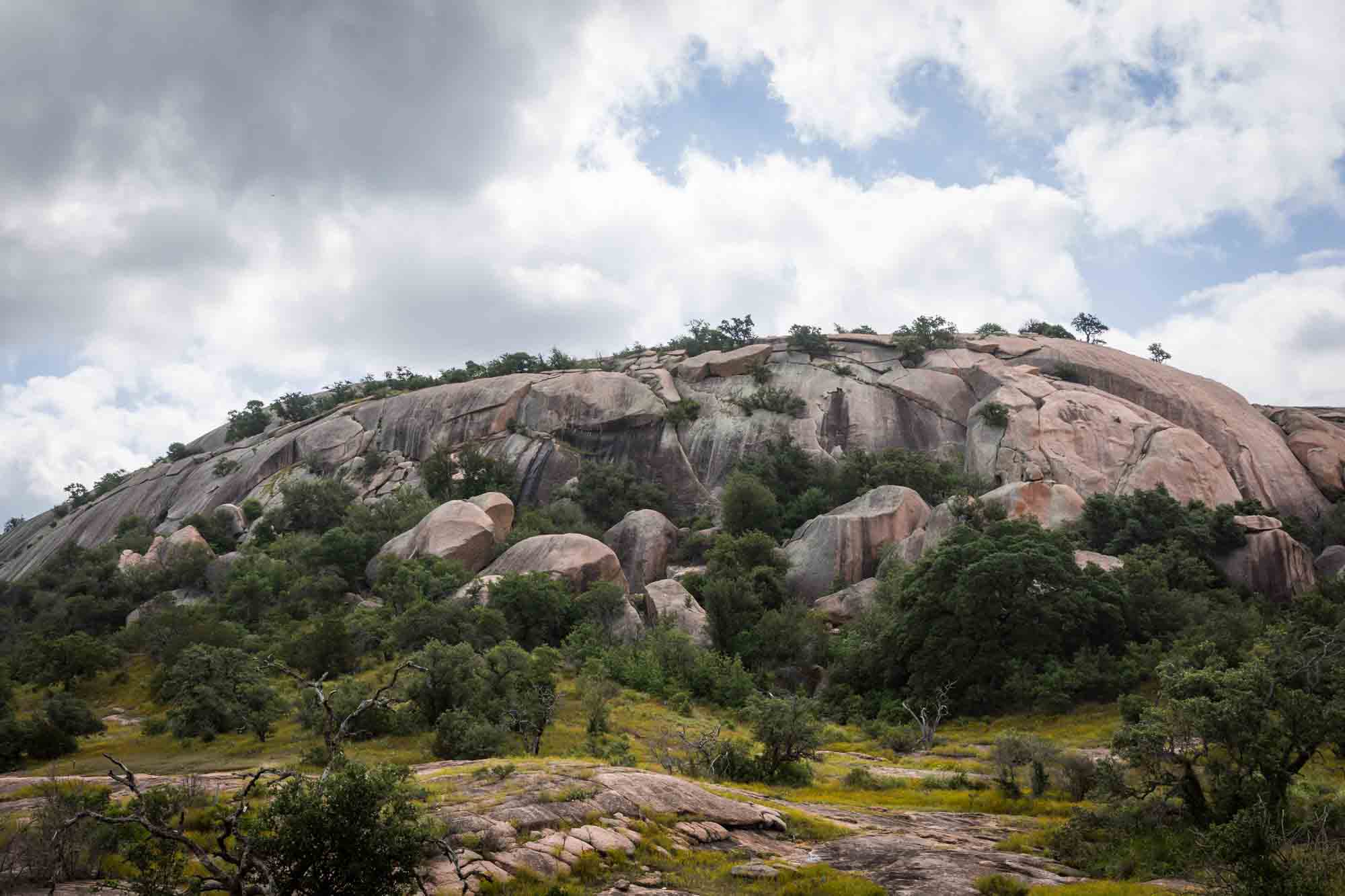 Large rock formation with trees for an article on Enchanted Rock hiking trips