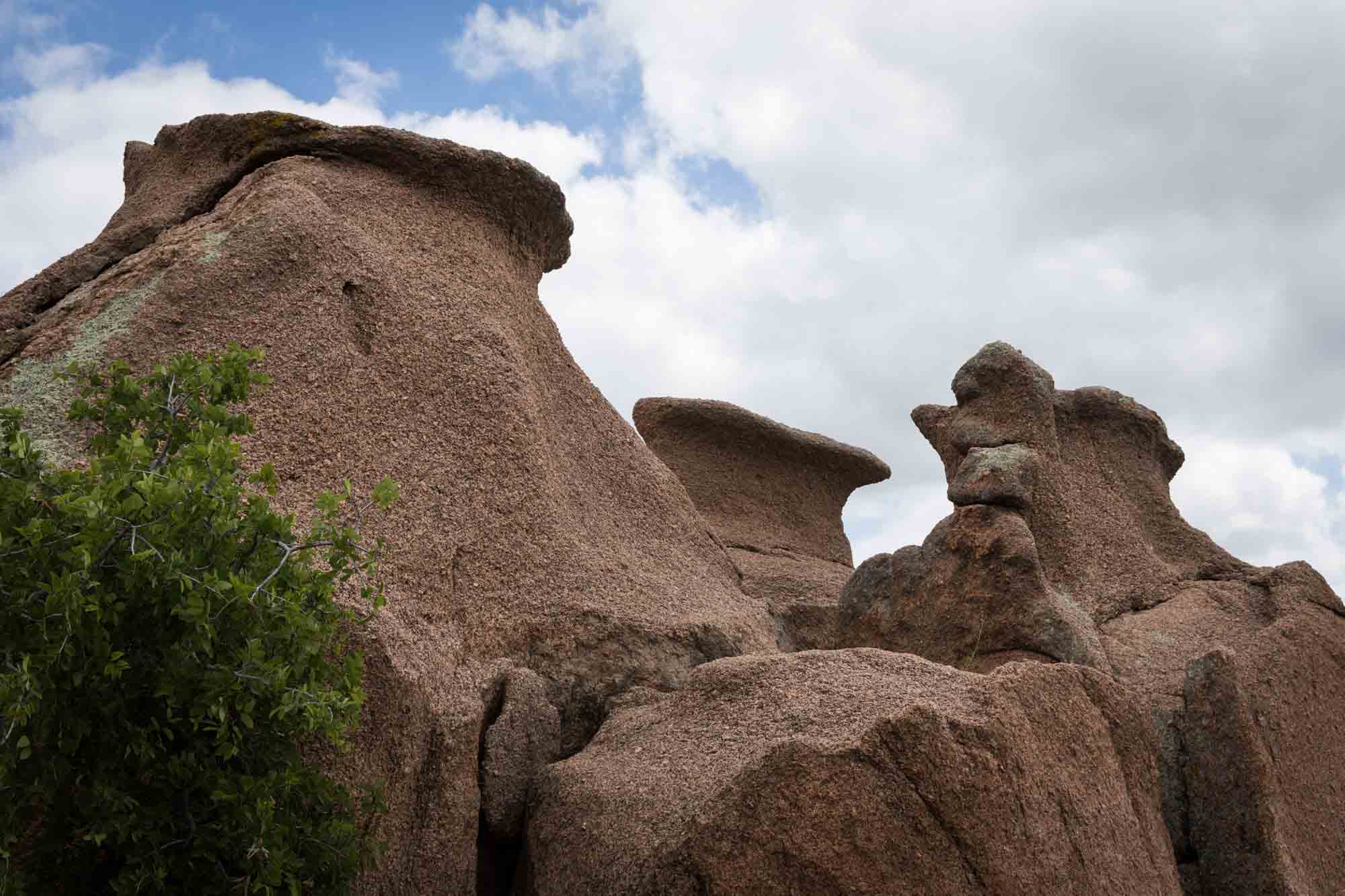 Weird rock formations against clouds in the sky for an article on Enchanted Rock hiking trips