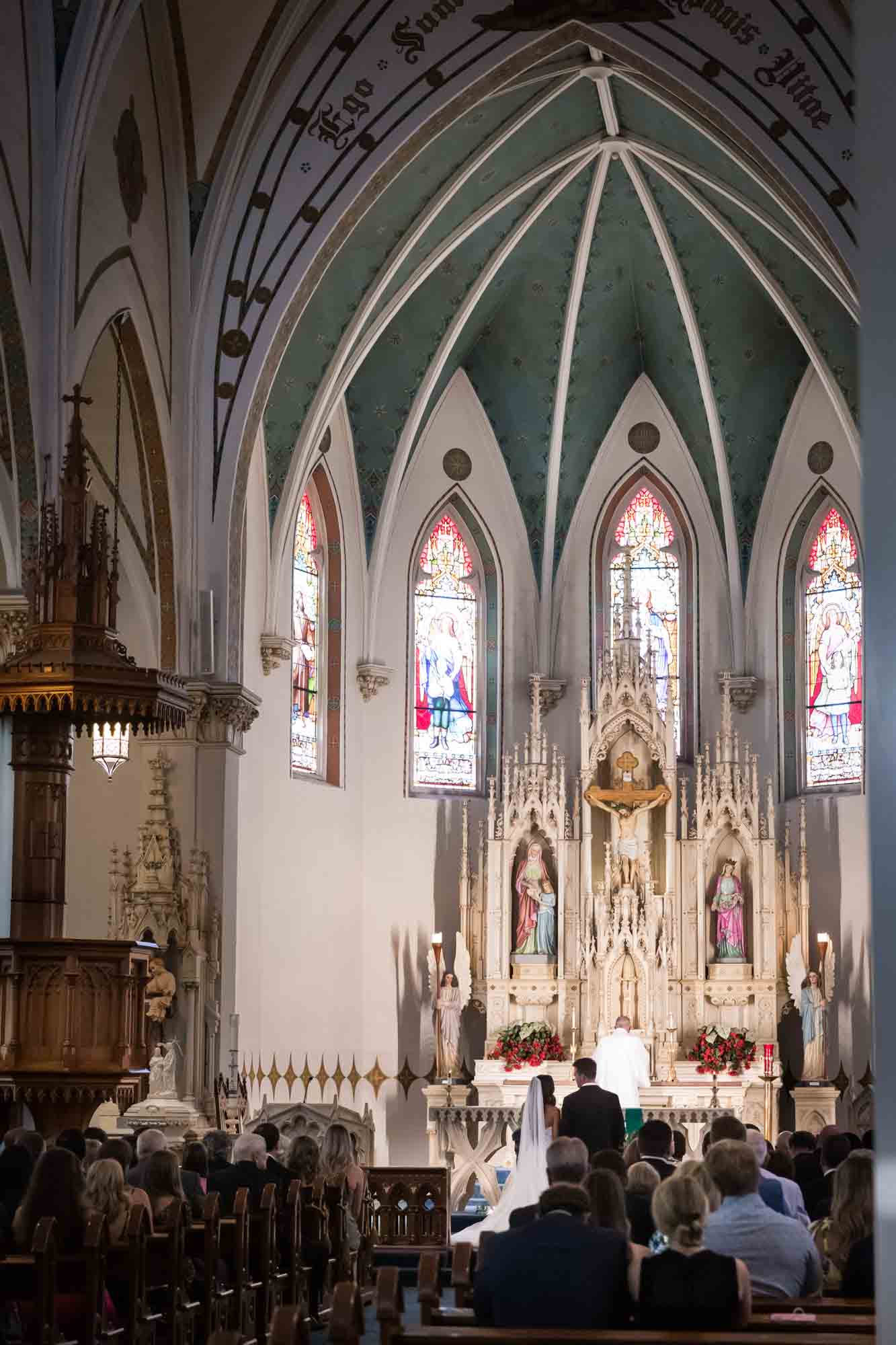 Wedding ceremony happening in the Interior of St. Mary's Catholic Church in Fredericksburg