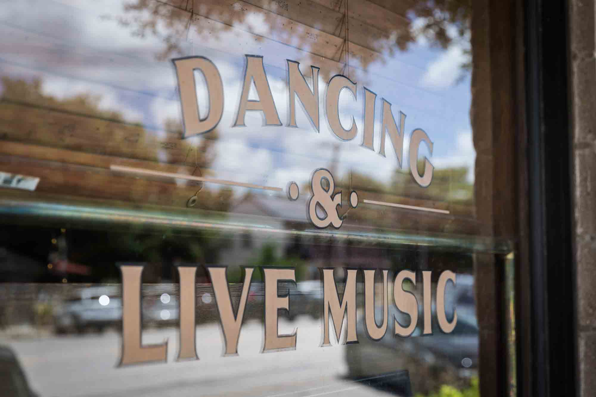 Window signage saying dancing and live music in Fredericksburg