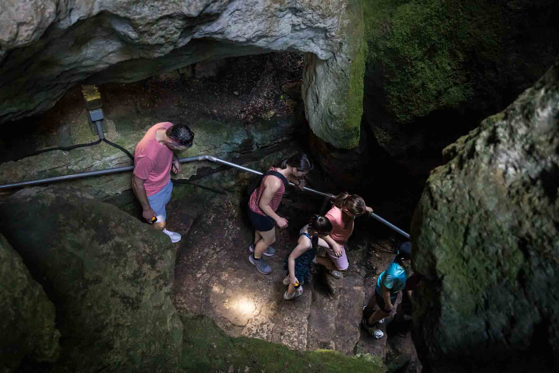 Visitors walking down stone staircase in Cascade Caverns for an article entitled, ‘Visiting Boerne, Texas: Everything You Need to Know’