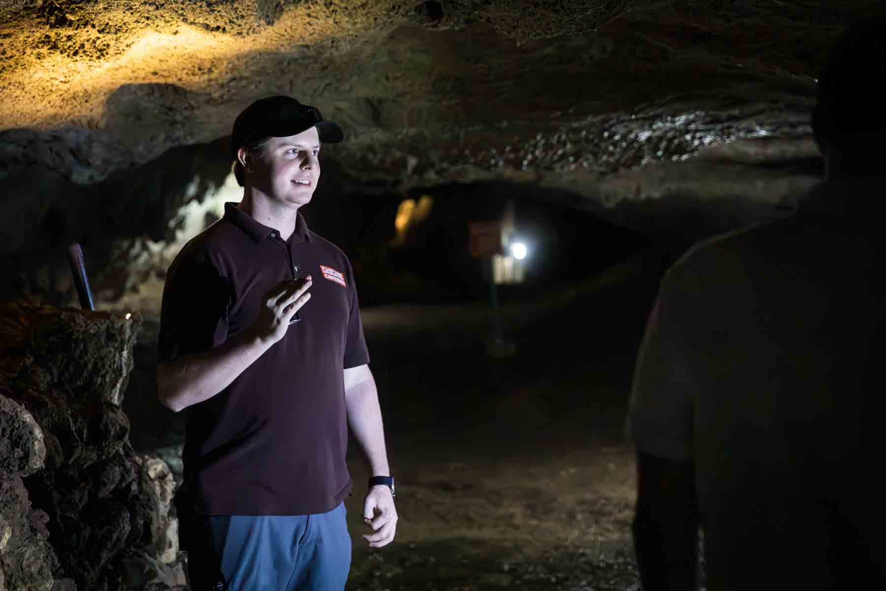 Tour guide holding flashlight in Cascade Caverns for an article entitled, ‘Visiting Boerne, Texas: Everything You Need to Know’