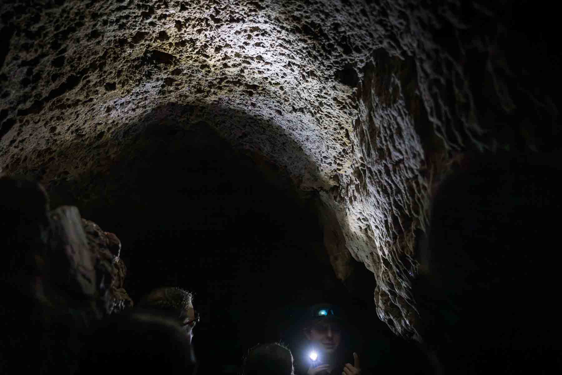 Visitors underneath rock formation in Cascade Caverns for an article entitled, ‘Visiting Boerne, Texas: Everything You Need to Know’