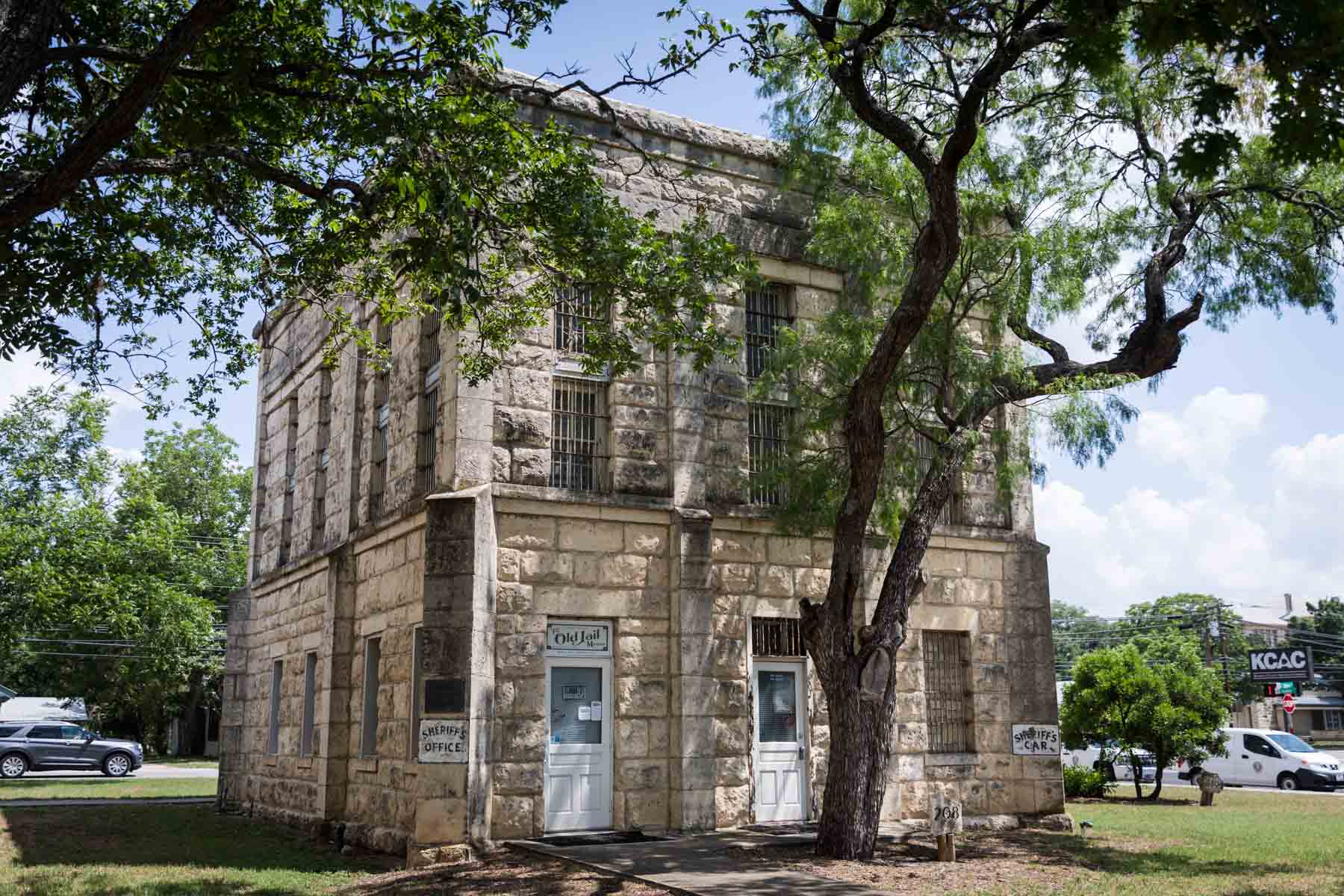 Old jail building surrounded by trees for an article entitled, ‘Visiting Boerne, Texas: Everything You Need to Know’