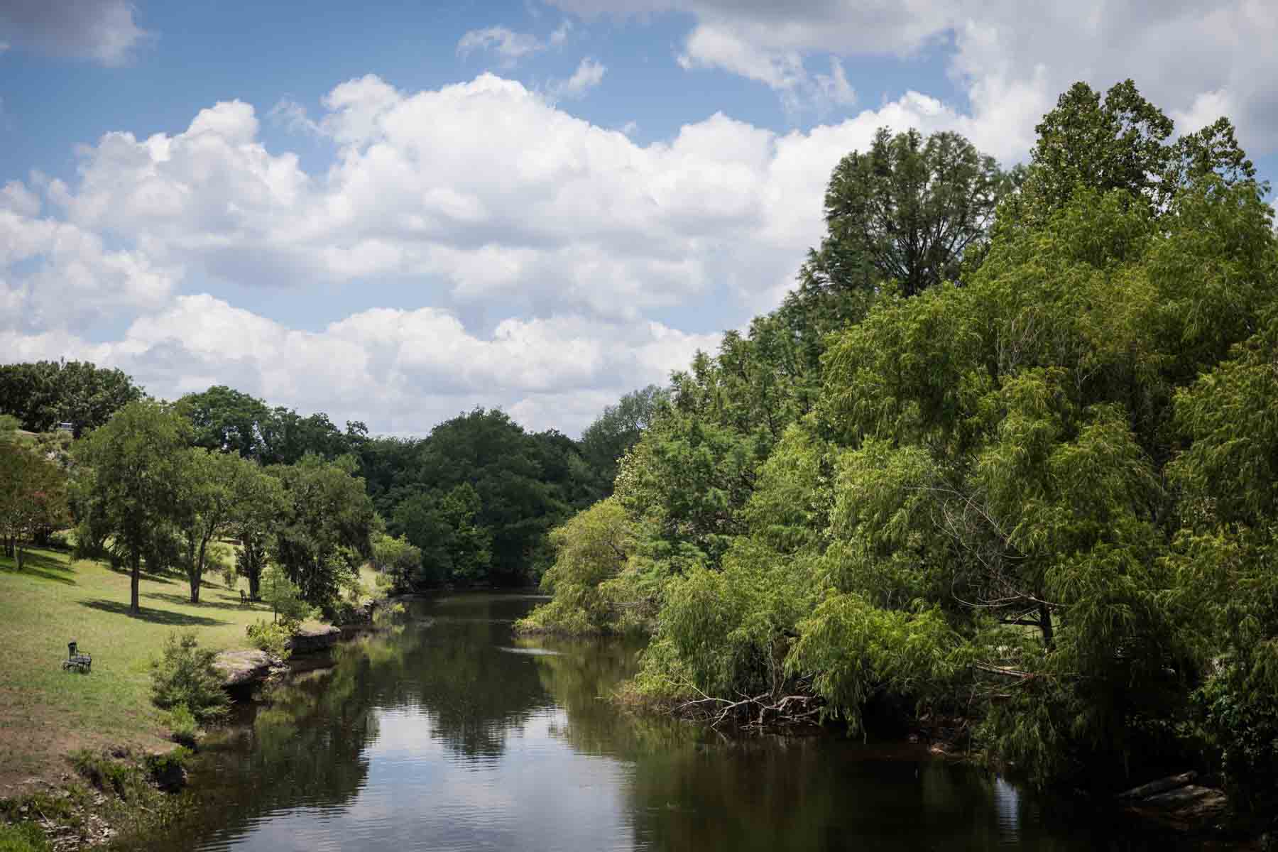 Brown water of Cibolo Creek with trees on banks for an article entitled, ‘Visiting Boerne, Texas: Everything You Need to Know’