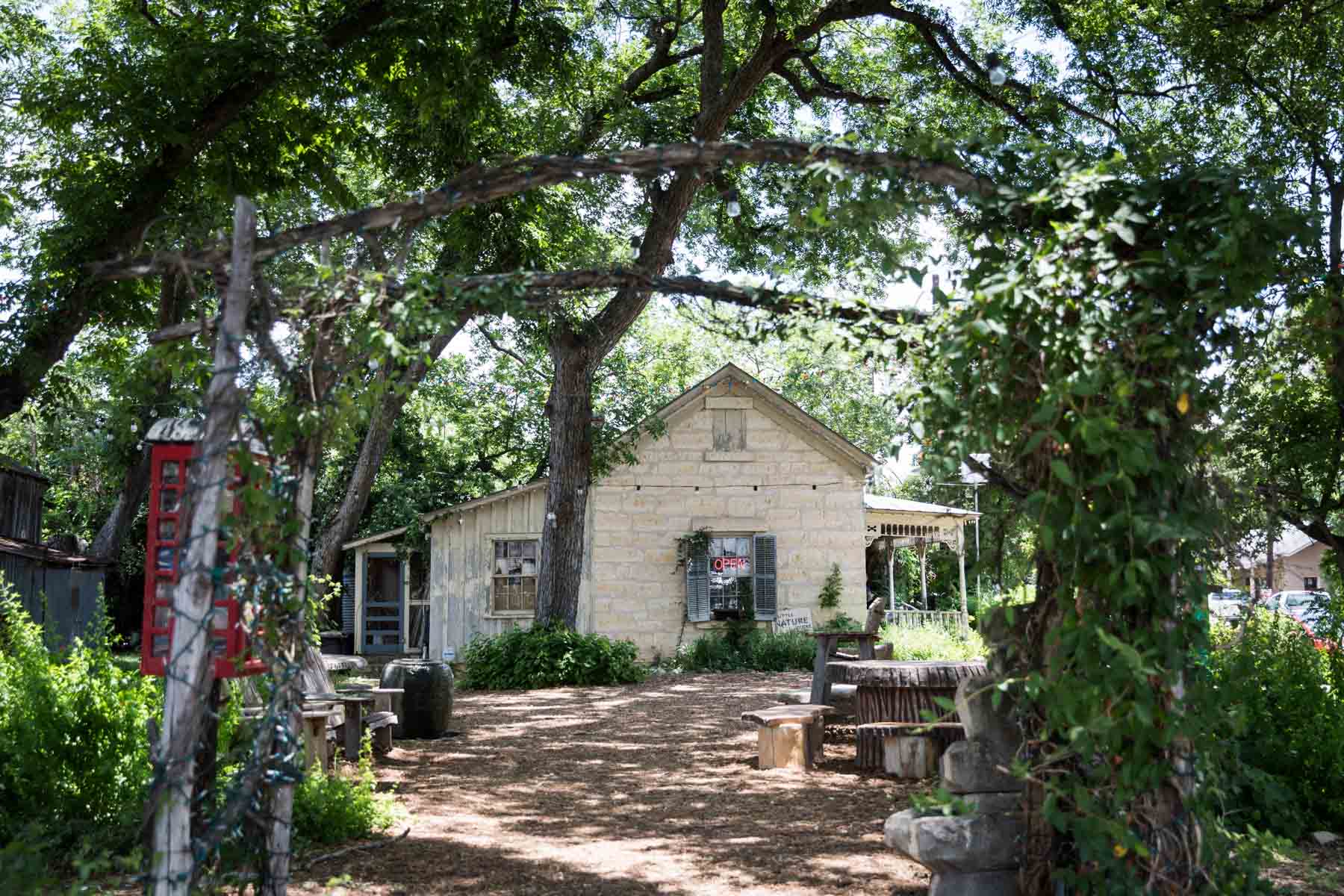 Pathway through forest leading to house with open sign for an article entitled, ‘Visiting Boerne, Texas: Everything You Need to Know’