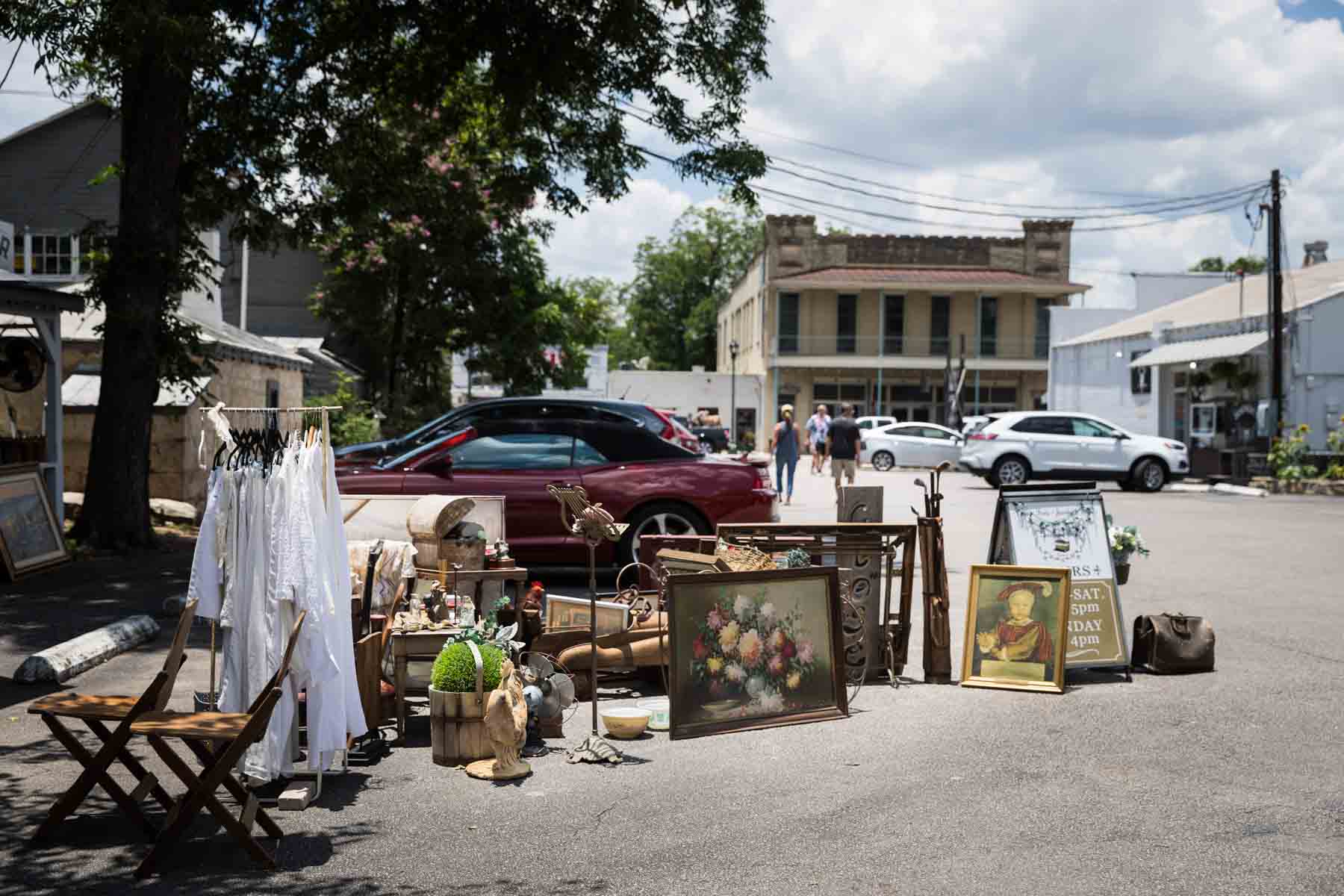 Paintings, clothing, and antiques displayed in a parking lot in Boerne for an article entitled, ‘Visiting Boerne, Texas: Everything You Need to Know’