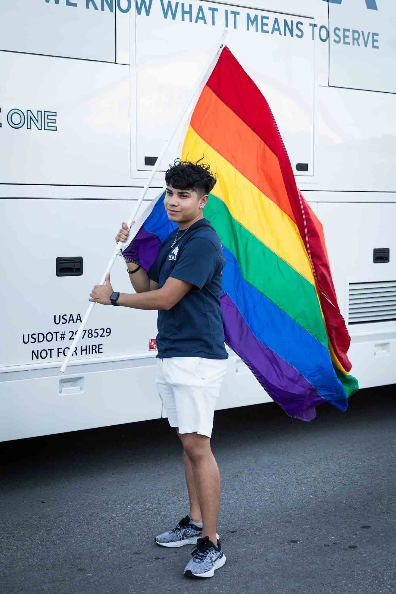 San Antonio gay pride parade photos of young man holding large rainbow flag