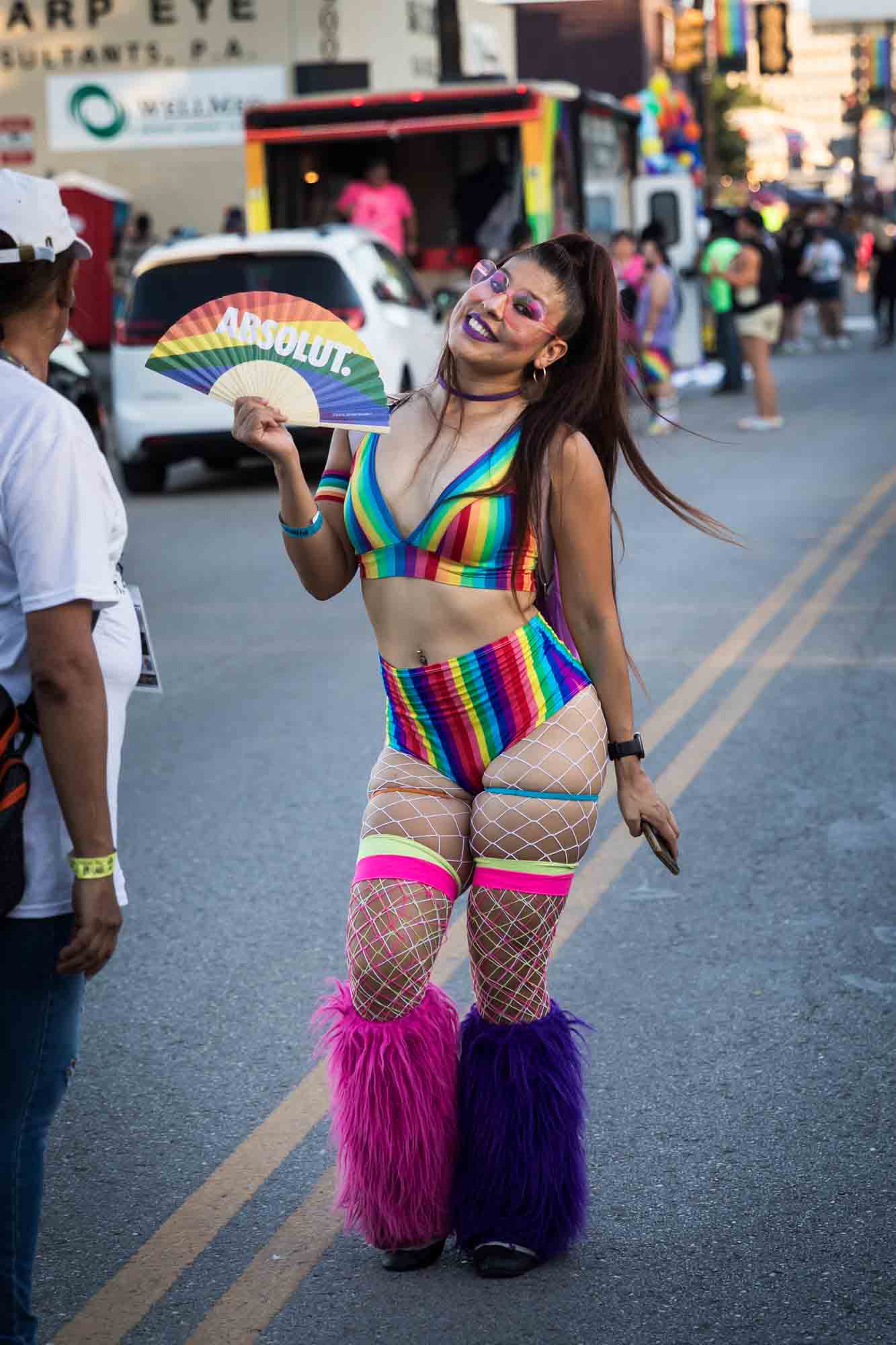 San Antonio gay pride parade photos of colorfully dressed woman holding rainbow fan