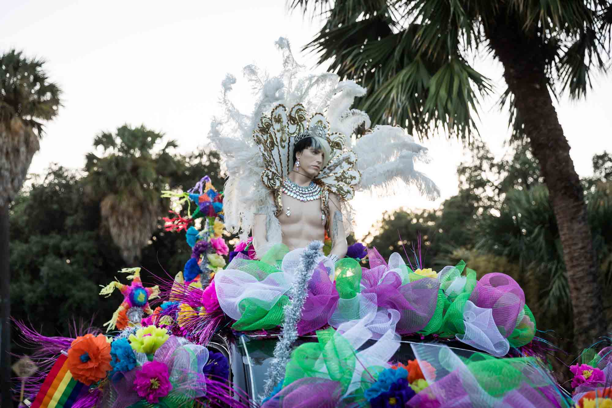 San Antonio gay pride parade photos of mannequin with white feathers on top of colorful parade float