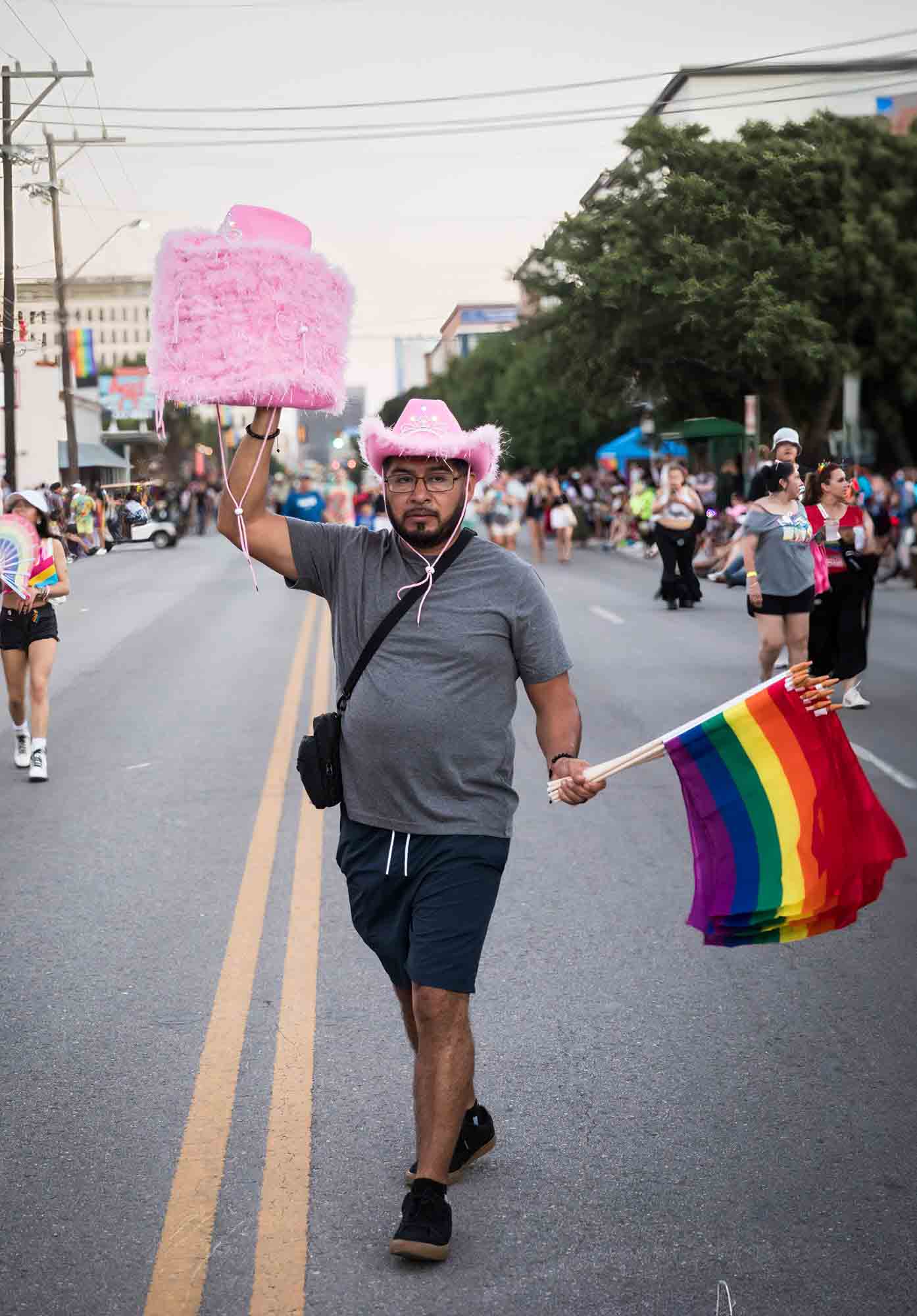 San Antonio gay pride parade photos of a vendor selling pink cowboy hats and rainbow flags