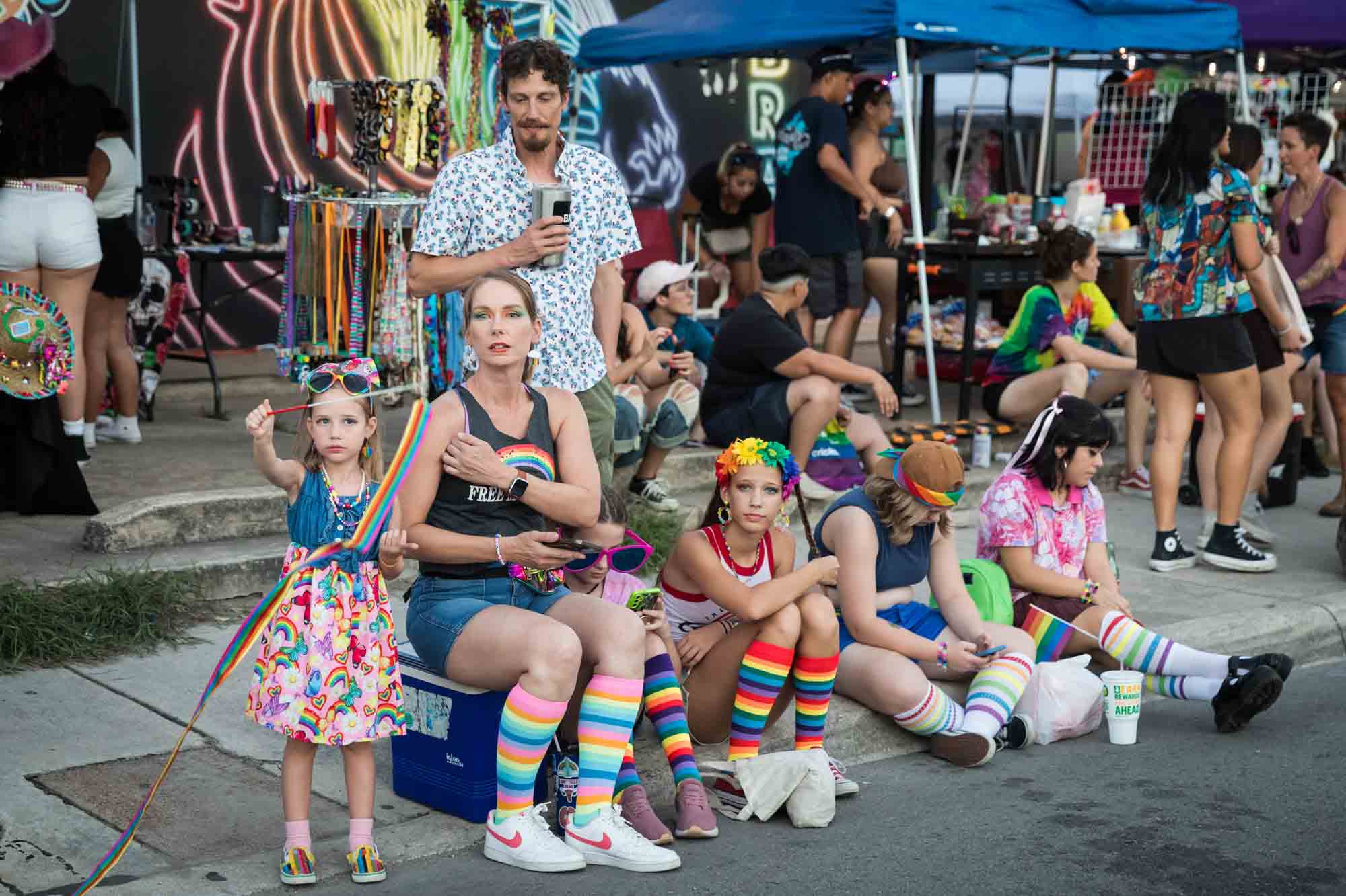 San Antonio gay pride parade photos of a family sitting on the curb waiting for the parade to begin