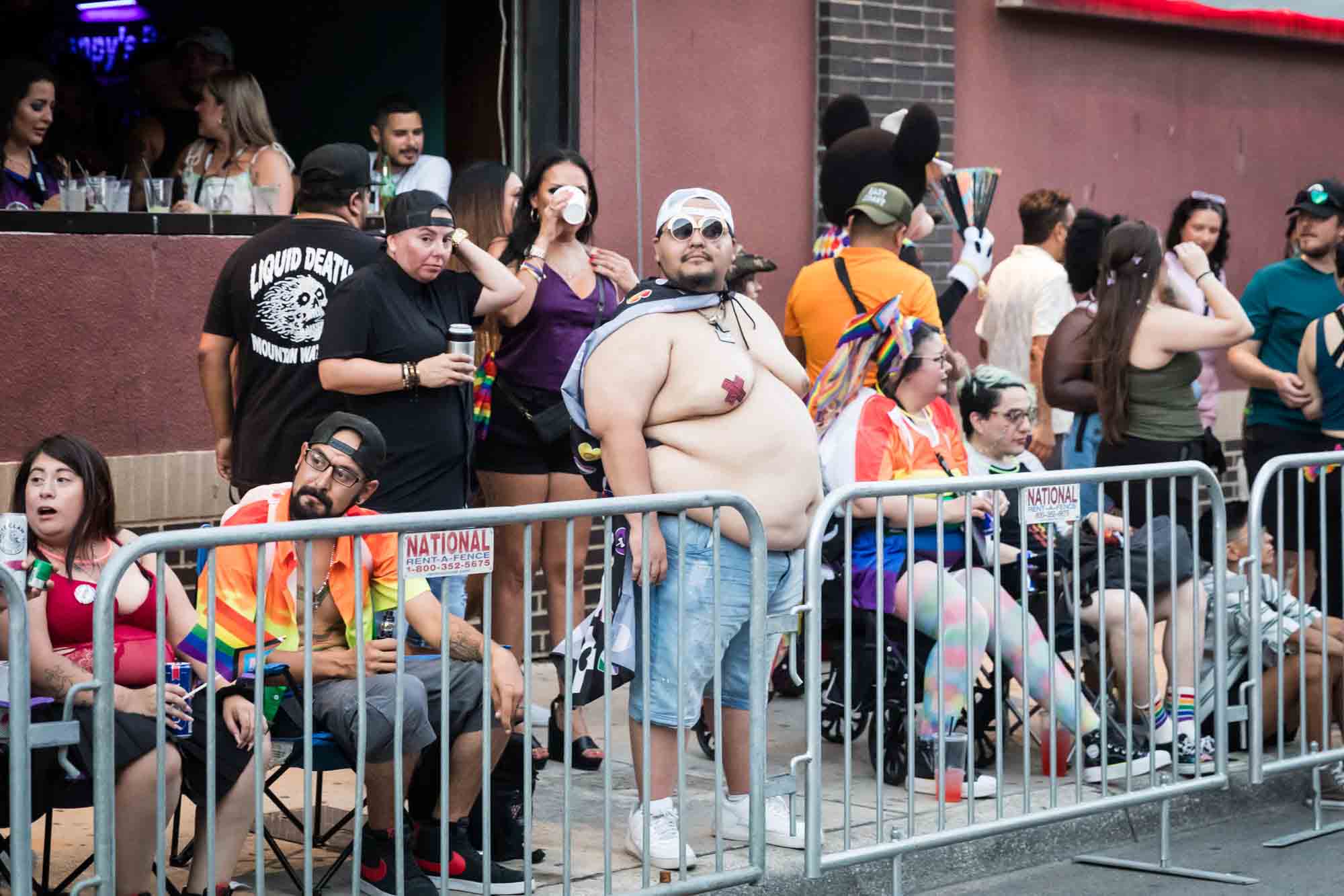 San Antonio gay pride parade photos of people leaning against metal railing waiting for parade to begin