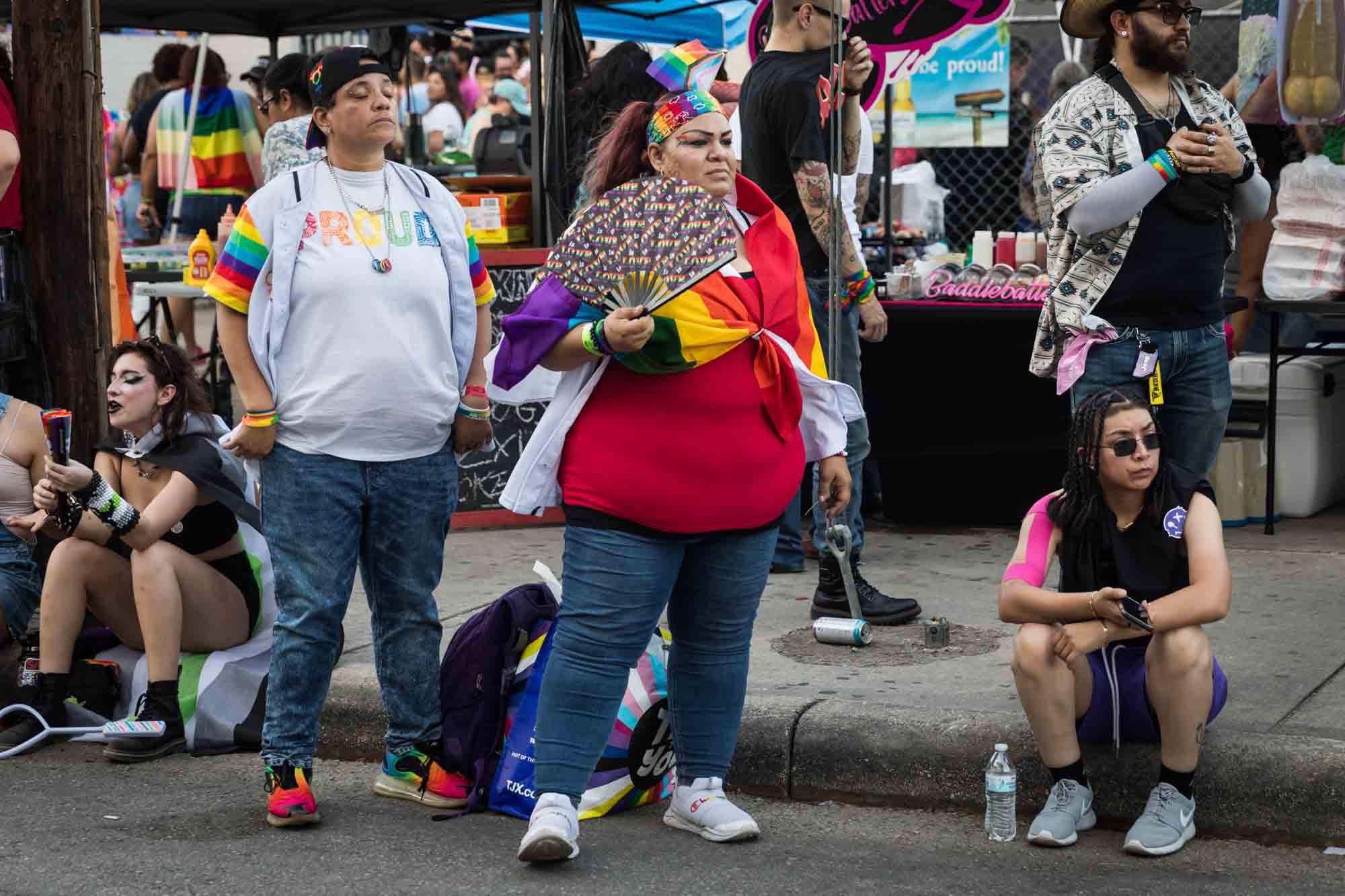 San Antonio gay pride parade photos of woman wearing red shirt and holding fan waiting for parade to begin