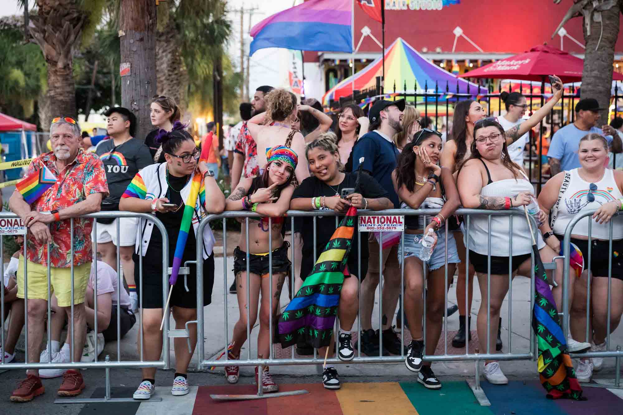 San Antonio gay pride parade photos of people leaning against metal railing waiting for parade to begin